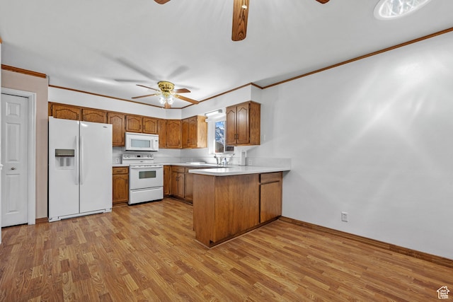 kitchen featuring ceiling fan, a peninsula, white appliances, light countertops, and brown cabinetry