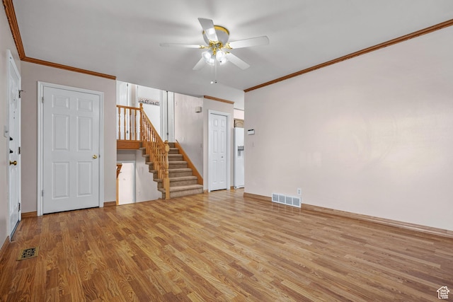 spare room featuring visible vents, light wood-style flooring, stairway, ornamental molding, and ceiling fan