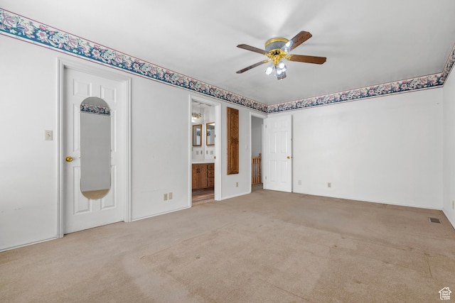 empty room featuring a ceiling fan, light colored carpet, and visible vents