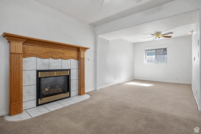 unfurnished living room with light carpet, ceiling fan, a tile fireplace, and baseboards