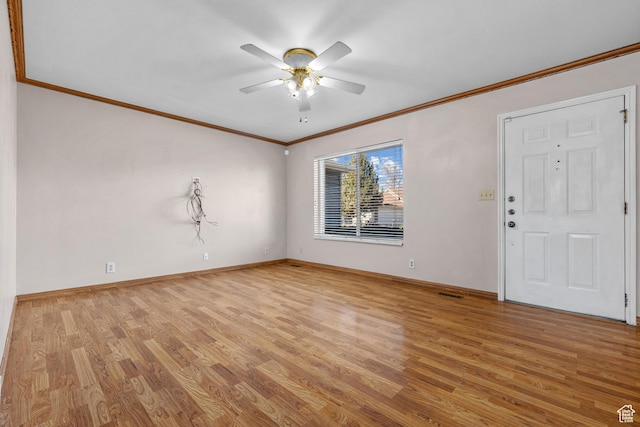 interior space with baseboards, crown molding, a ceiling fan, and light wood-style floors