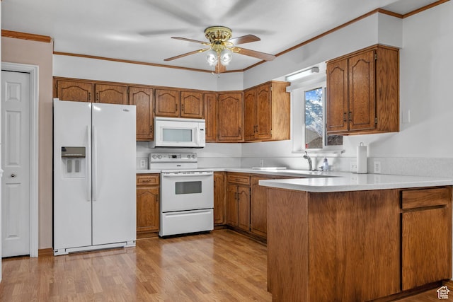 kitchen with ornamental molding, light countertops, white appliances, and brown cabinetry