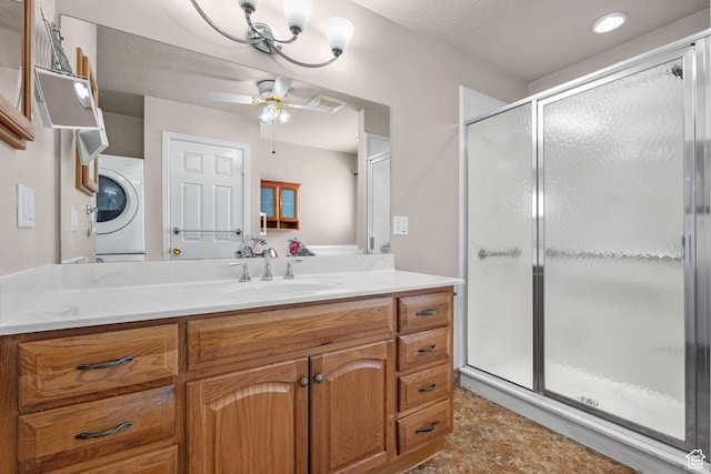 bathroom featuring a stall shower, washer / clothes dryer, a ceiling fan, and vanity