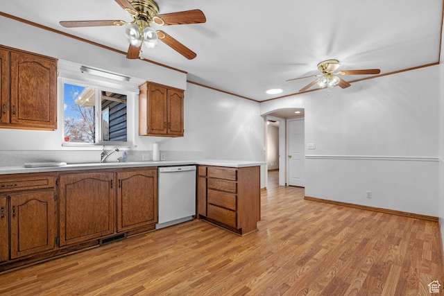 kitchen featuring visible vents, brown cabinets, white dishwasher, light countertops, and crown molding