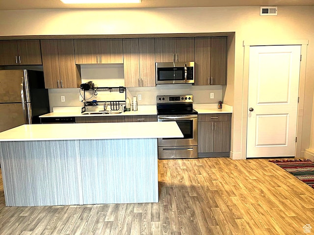 154 E 7th St S Unit A101, Ogden, UT 84404 - kitchen with appliances with stainless steel finishes, light wood finished floors, light countertops, and a kitchen island