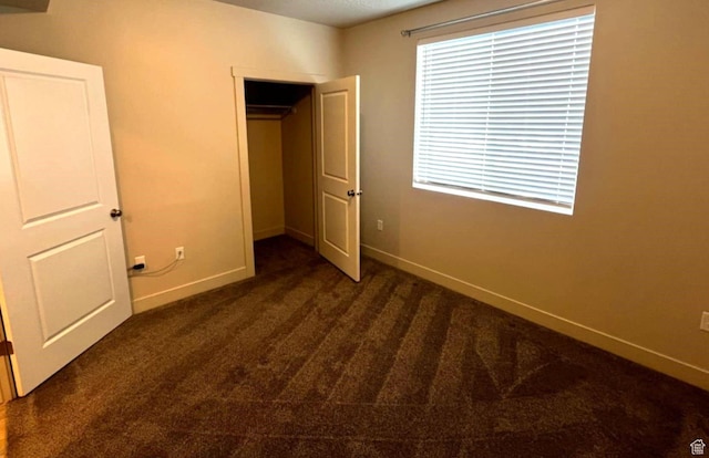 154 E 7th St S Unit A101, Ogden, UT 84404 - unfurnished bedroom with dark colored carpet, baseboards, and a closet