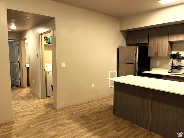 154 E 7th St S Unit A101, Ogden, UT 84404 - kitchen featuring freestanding refrigerator, light wood finished floors, light countertops, a sink, and baseboards
