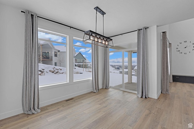 680 E 525 N, Providence, UT 84332 - unfurnished dining area featuring wood finished floors, visible vents, an inviting chandelier, and a healthy amount of sunlight