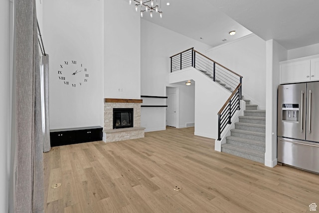 680 E 525 N, Providence, UT 84332 - unfurnished living room with light wood-style flooring, stairway, a notable chandelier, and baseboards