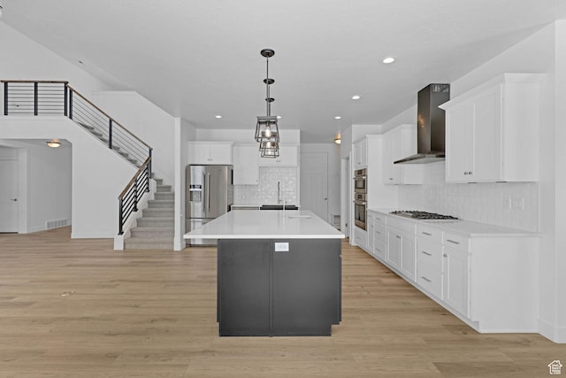 680 E 525 N, Providence, UT 84332 - kitchen featuring wall chimney range hood, white cabinets, visible vents, appliances with stainless steel finishes, and a sink