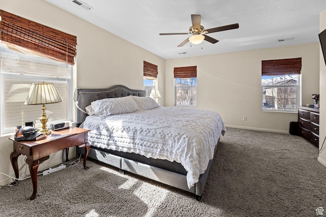 bedroom featuring dark colored carpet, visible vents, baseboards, and multiple windows