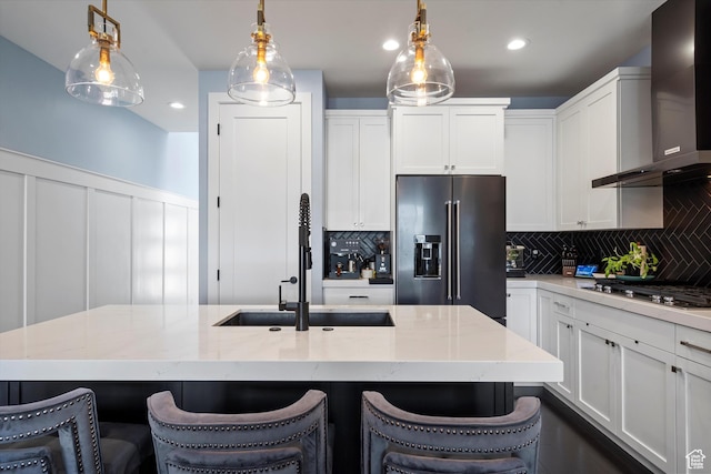1313 E Daffodil Ct, Layton, UT 84040 - kitchen with appliances with stainless steel finishes, decorative light fixtures, wall chimney exhaust hood, and a kitchen bar