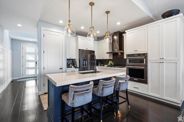 1313 E Daffodil Ct, Layton, UT 84040 - kitchen with an island with sink, wall chimney exhaust hood, hanging light fixtures, light countertops, and white cabinetry