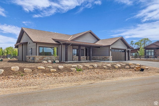 272 Thorn Creek Dr, Kamas, UT 84036 - view of front facade featuring stone siding, driveway, a garage, and a shingled roof