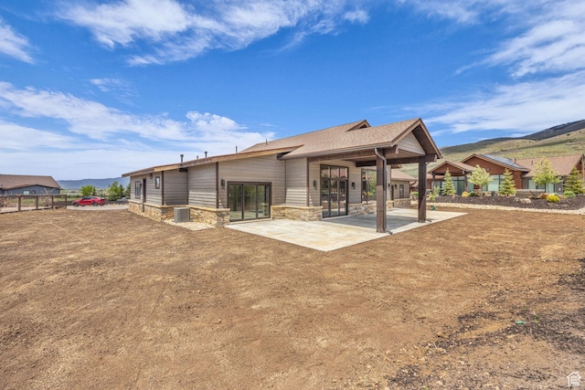 272 Thorn Creek Dr, Kamas, UT 84036 - back of house featuring a patio area, stone siding, a mountain view, and central air condition unit