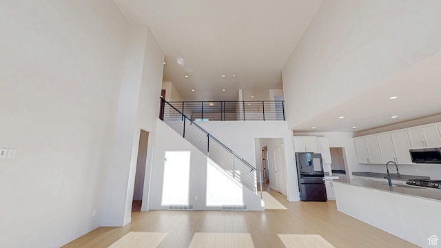 1396 S Castillo Rd W Unit 102, Spanish Fork, UT 84660 - kitchen with light wood-type flooring, stainless steel microwave, white cabinets, and freestanding refrigerator