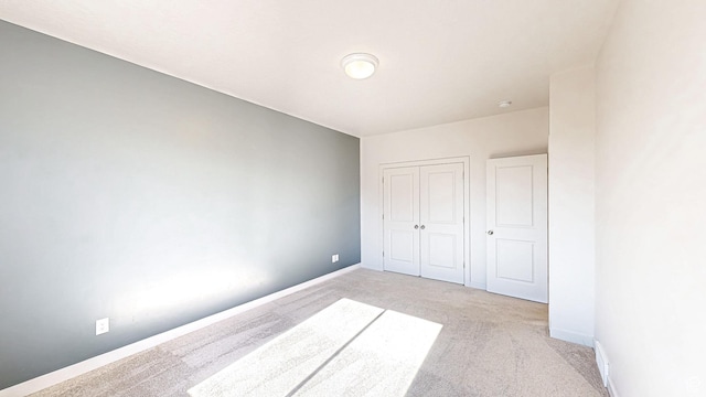 1396 S Castillo Rd W Unit 102, Spanish Fork, UT 84660 - unfurnished bedroom featuring baseboards, a closet, and light colored carpet