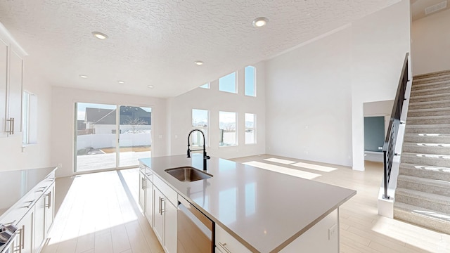 1396 S Castillo Rd W Unit 102, Spanish Fork, UT 84660 - kitchen featuring visible vents, a kitchen island with sink, a sink, white cabinetry, and dishwasher