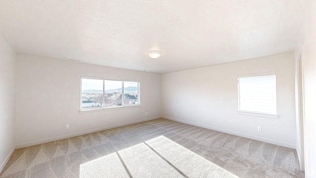 1396 S Castillo Rd W Unit 102, Spanish Fork, UT 84660 - spare room with visible vents, light carpet, a textured ceiling, and baseboards
