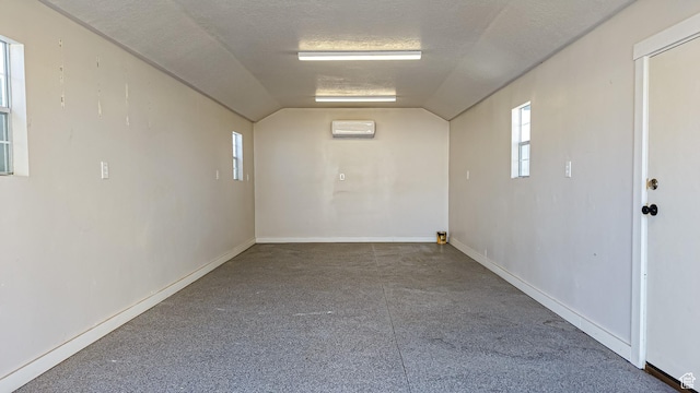 1396 S Castillo Rd W Unit 102, Spanish Fork, UT 84660 - empty room with a textured ceiling, vaulted ceiling, a wall unit AC, and baseboards
