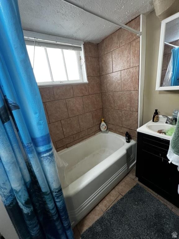 bathroom featuring shower / bathtub combination with curtain, vanity, a textured ceiling, and tile patterned floors