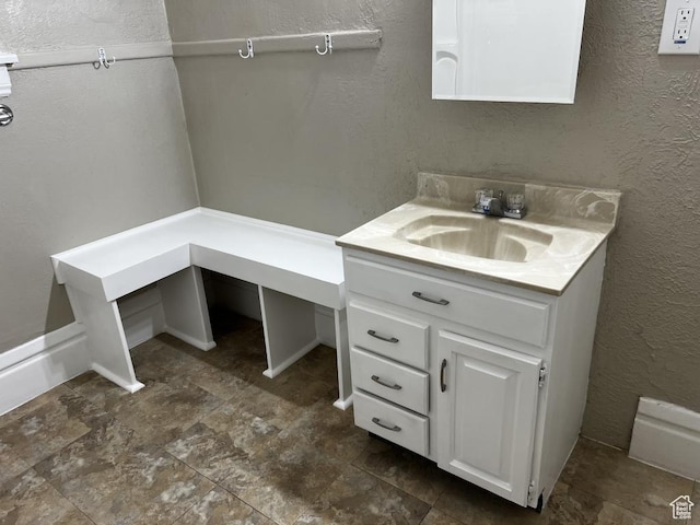 bathroom featuring a textured wall and vanity