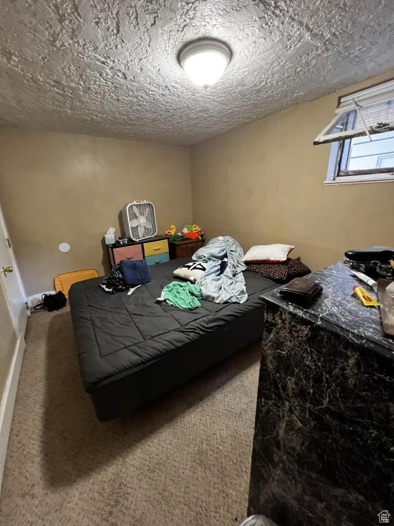 bedroom with carpet flooring, a textured ceiling, and baseboards
