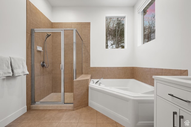 bathroom featuring a stall shower, a bath, vanity, and tile patterned floors