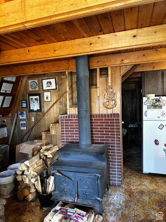 297 E Solomons Way, Manila, UT 84046 - room details with freestanding refrigerator, a wood stove, wood walls, and beam ceiling