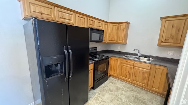 kitchen with black appliances, a sink, and dark countertops
