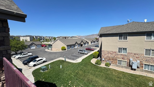 exterior space featuring a residential view, uncovered parking, and a lawn