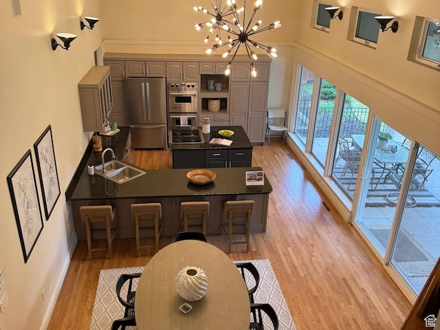 2765 E Blue Spruce Dr, Holladay, UT 84117 - dining space featuring a towering ceiling, light wood-style flooring, a chandelier, and baseboards