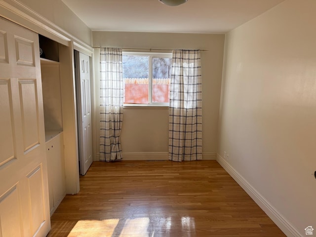 interior space with baseboards and wood finished floors