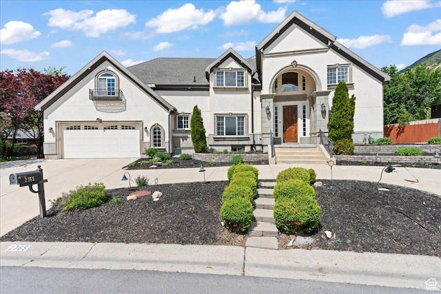view of front of home featuring driveway, an attached garage, and stucco siding