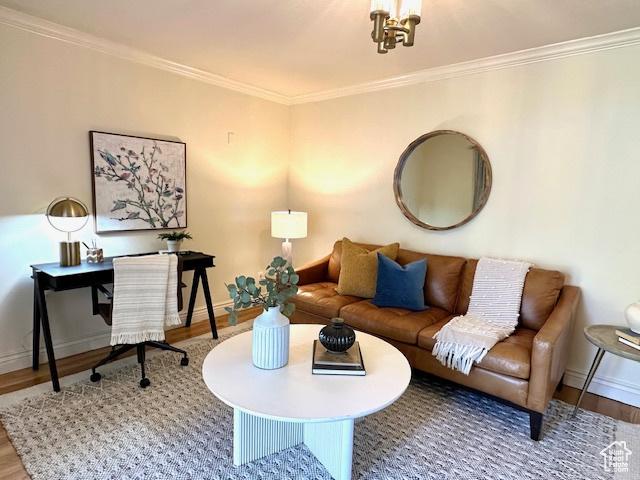 living room with wood finished floors, baseboards, and ornamental molding