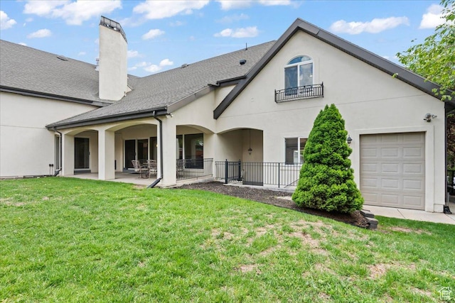 back of house featuring a chimney, a lawn, fence, a patio area, and stucco siding