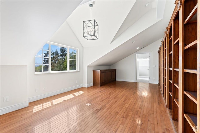 bonus room featuring lofted ceiling, baseboards, light wood-style flooring, and a notable chandelier