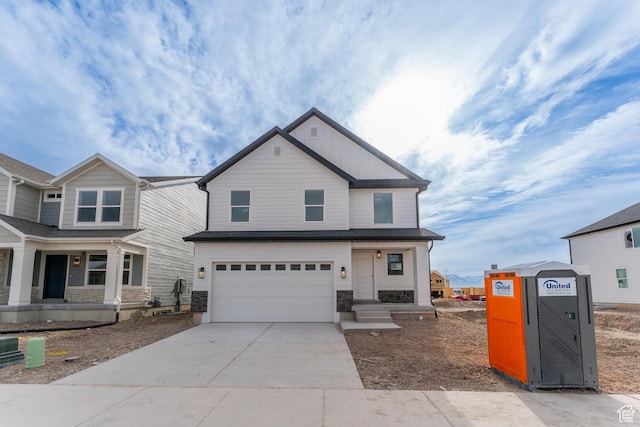 view of front facade featuring covered porch, a garage, driveway, and stone siding