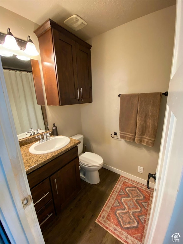 2573 S 2800 W, Roosevelt, UT 84066 - bathroom featuring visible vents, toilet, vanity, wood finished floors, and baseboards