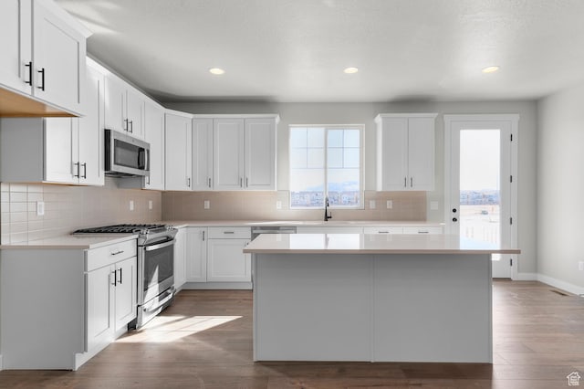3707 W 2600 N, Lehi, UT 84043 - kitchen featuring light countertops, appliances with stainless steel finishes, wood finished floors, white cabinetry, and a sink