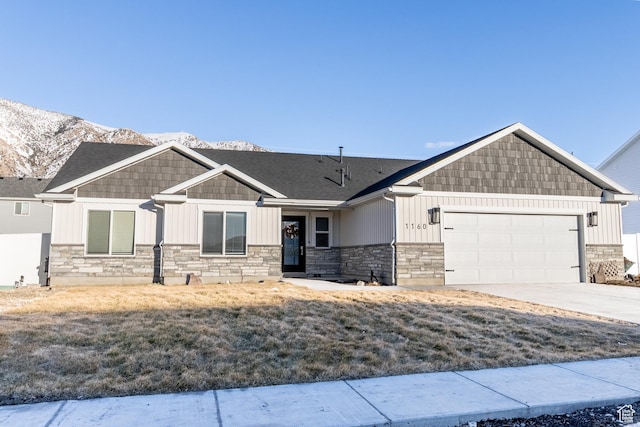 craftsman-style house with a garage, concrete driveway, a mountain view, and board and batten siding