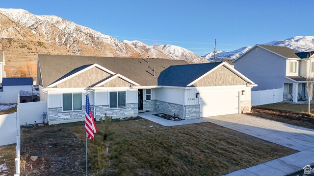 view of front facade with a garage, stone siding, and a mountain view