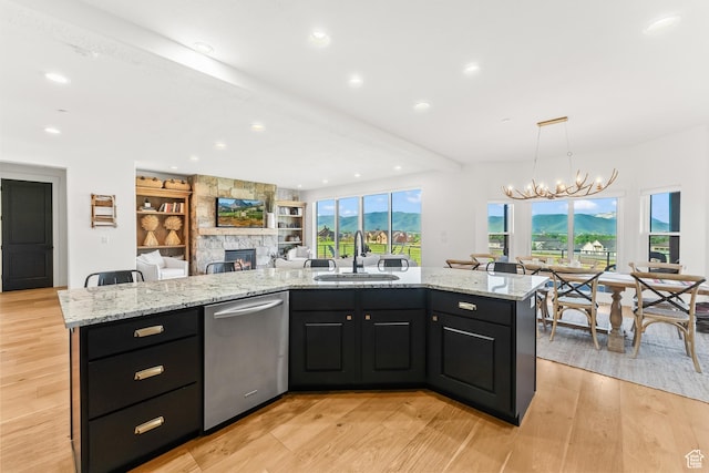 615 N Haystack Mountain Dr, Heber City, UT 84032 - kitchen with stainless steel dishwasher, open floor plan, a kitchen island with sink, a sink, and dark cabinets