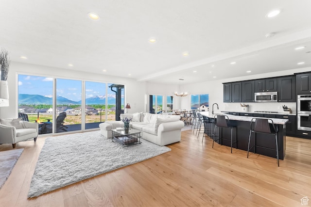 615 N Haystack Mountain Dr, Heber City, UT 84032 - living room with a notable chandelier, beam ceiling, a mountain view, and light wood-style floors