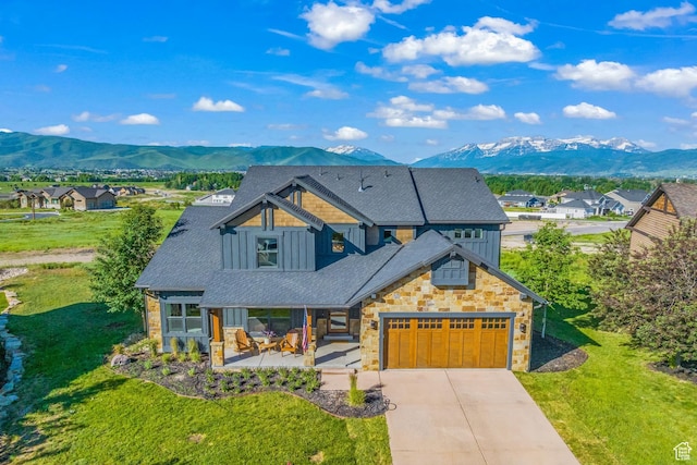 view of front of house with driveway, a residential view, a mountain view, and roof with shingles
