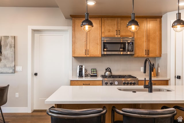 kitchen featuring stove, stainless steel microwave, light countertops, and decorative light fixtures