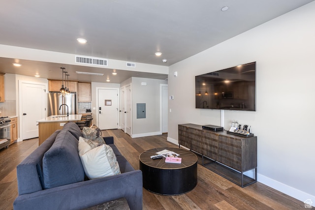 living room with baseboards, visible vents, dark wood finished floors, and recessed lighting