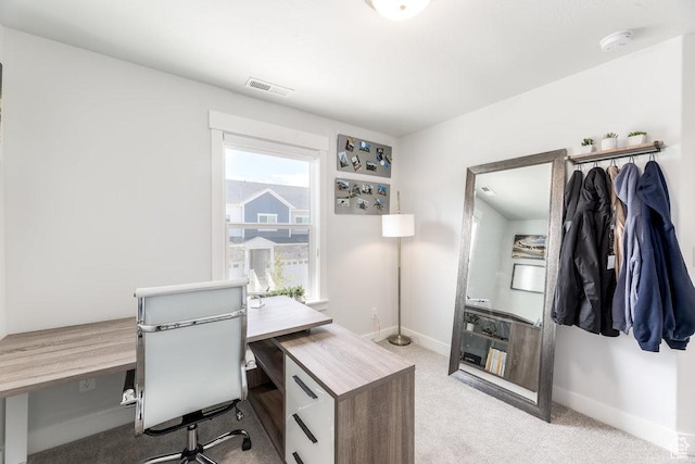 office space featuring light carpet, visible vents, and baseboards