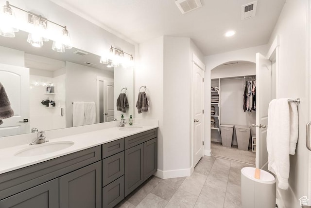 bathroom featuring double vanity, visible vents, and a sink