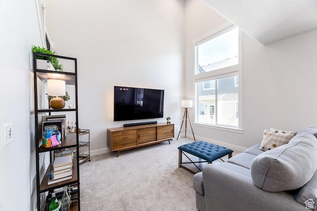 carpeted living room featuring baseboards
